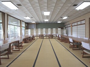 A conference room with tatami mats, wooden tables, and chairs. - Seizansou (Uji)