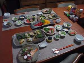 A dining table set with various dishes, chopsticks, and condiments. - Kamuro An (Kyoto)