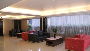 Uma sala de estar moderna com um sofá preto, um sofá vermelho e uma mesa de centro.
