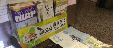 A display of travel maps and brochures for Taiwan, including a 'Taipei Map' and a 'Tour Bus' guide.
