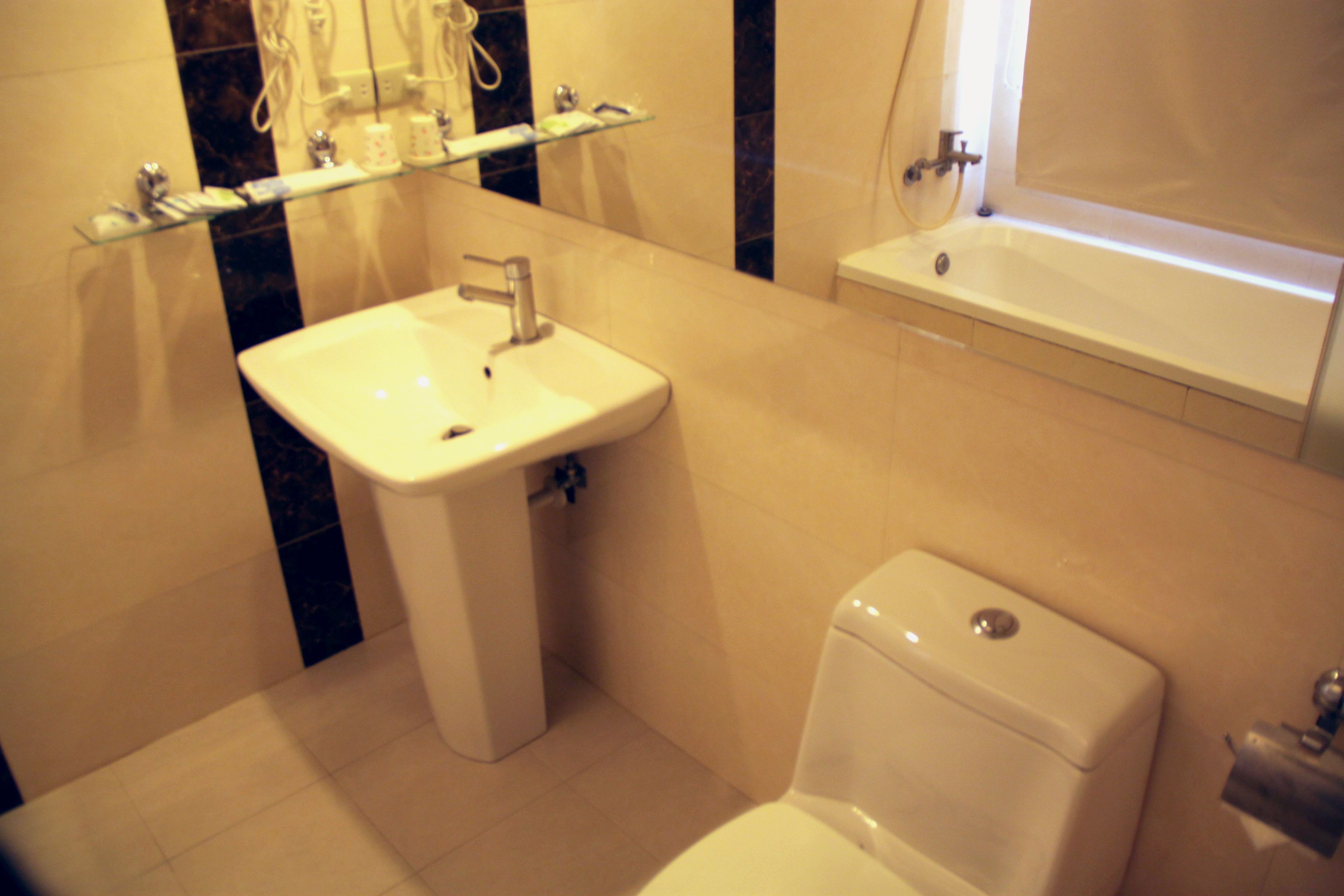 Un baño con lavamanos blanco, inodoro y bañera.