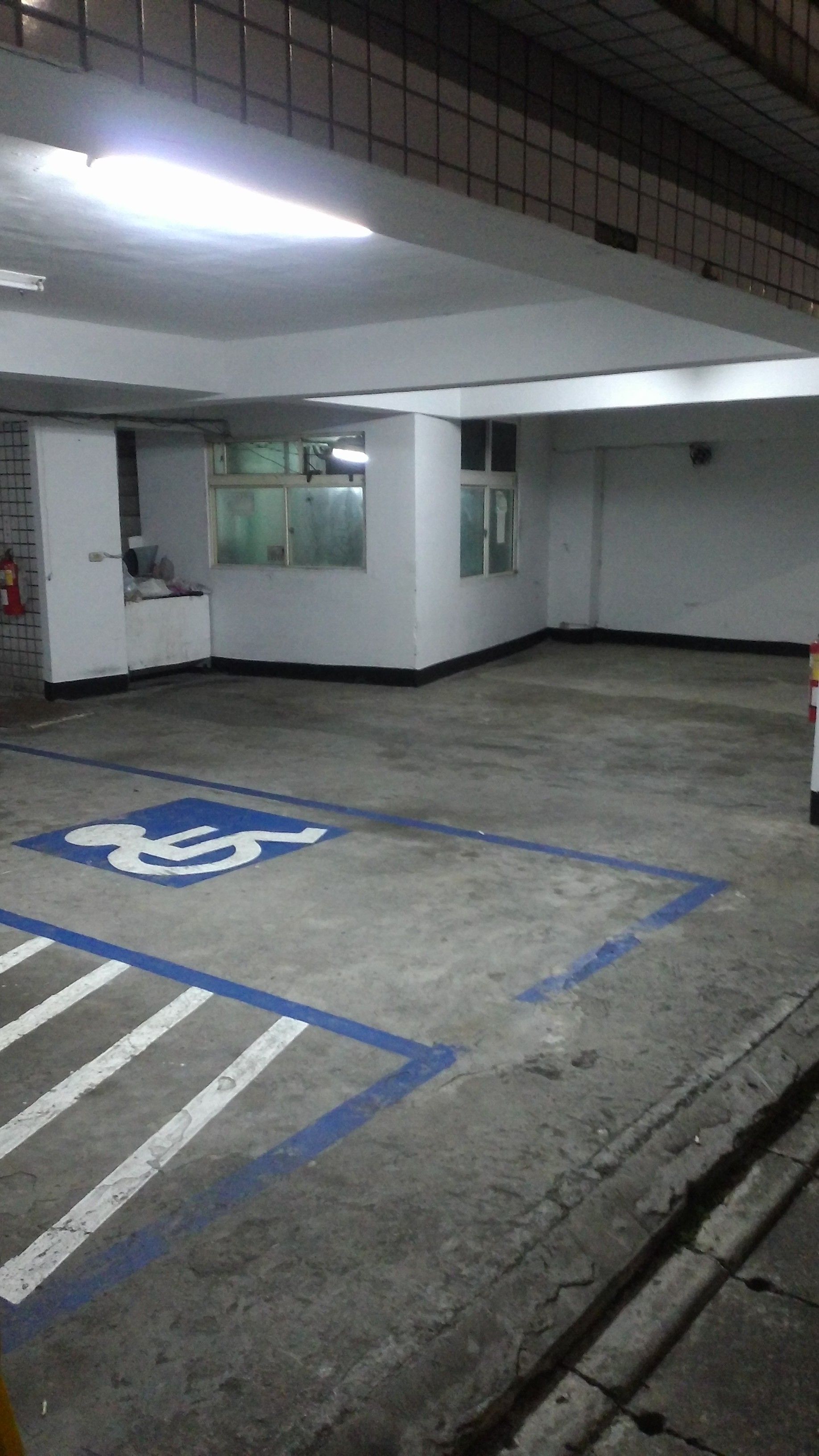 A parking garage with a handicapped parking space marked by a blue and white symbol.