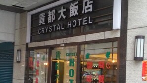 Exterior do Hotel Crystal, com uma placa em inglês e chinês.