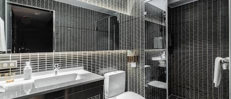 A modern bathroom with a large mirror, white sink, and a toilet.