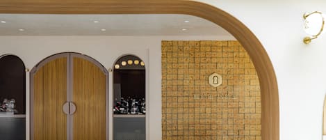 A hotel entrance with wooden doors, a wall with a textured pattern, and a sign with Chinese characters.