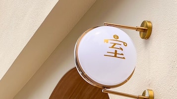 Un letrero circular sujeto a la pared, con un emblema dorado en un panel de madera.