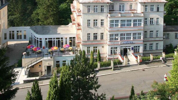 A multi-story hotel with a traditional architectural style, featuring a prominent central tower and multiple balconies. - Lázeňská Léčebna Mánes (Karlovy Vary)
