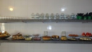 A kitchen with multiple shelves holding various food items and kitchenware. - Pousada Mirante das Águas (Aracaju)