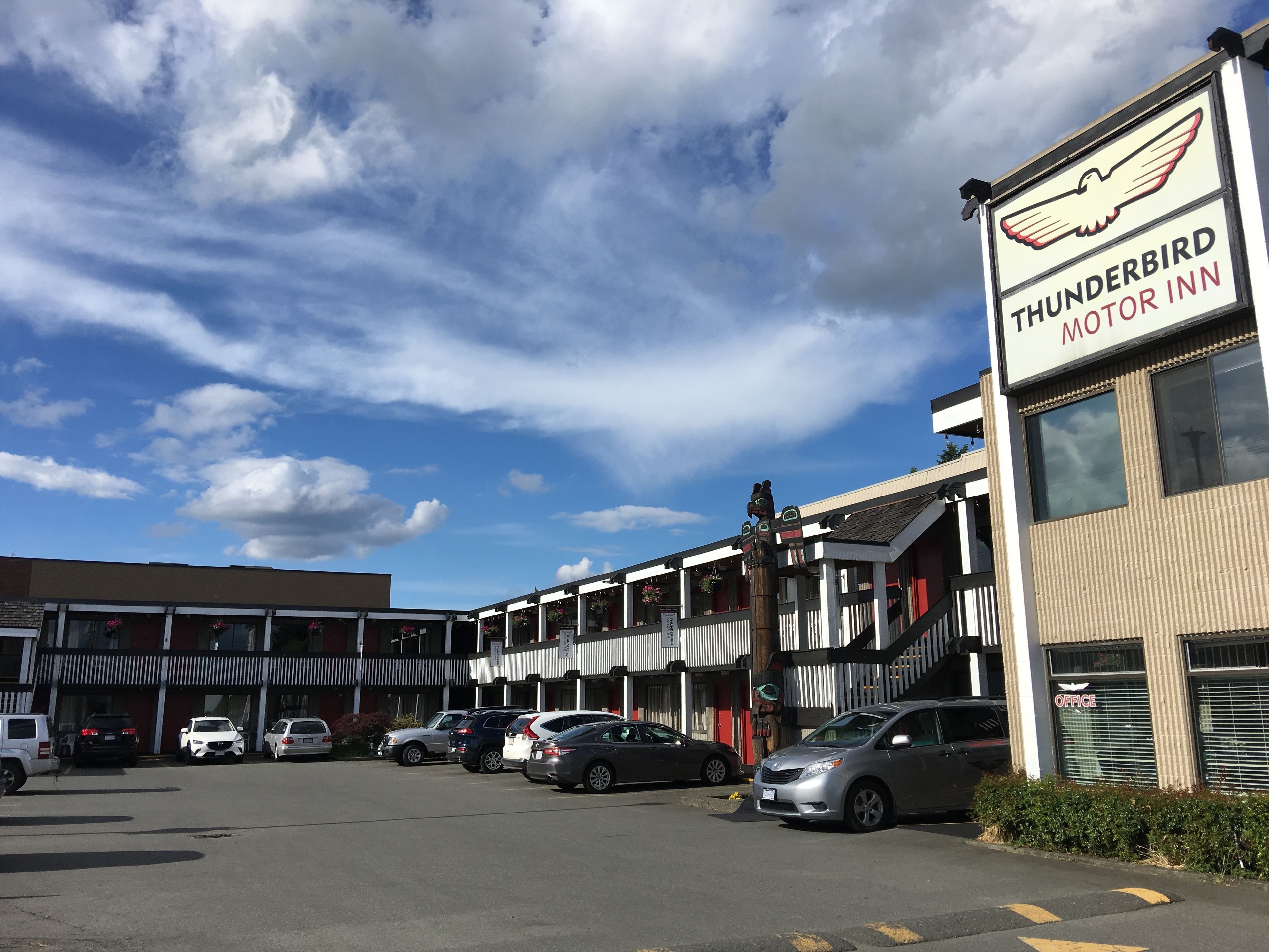 A building with a sign for 'Thunderbird Motor Inn' and several parked cars in front.