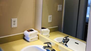 Een badkamer met een wit wastafel, een spiegel en een handdoekhouder.
