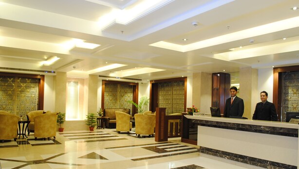 A hotel lobby with a reception desk, seating area, and decorative elements. - Hotel Libra (Jaipur)