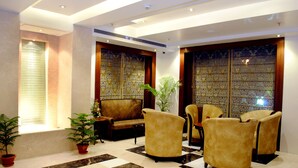A lobby with a checkered floor, a sofa, and four armchairs. - Hotel Libra (Jaipur)
