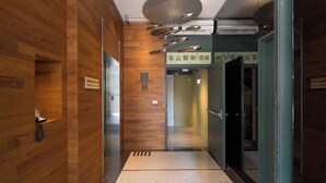 Een moderne hotellobby met houten lambrisering, een receptiebalie en een bord met de naam van het hotel.