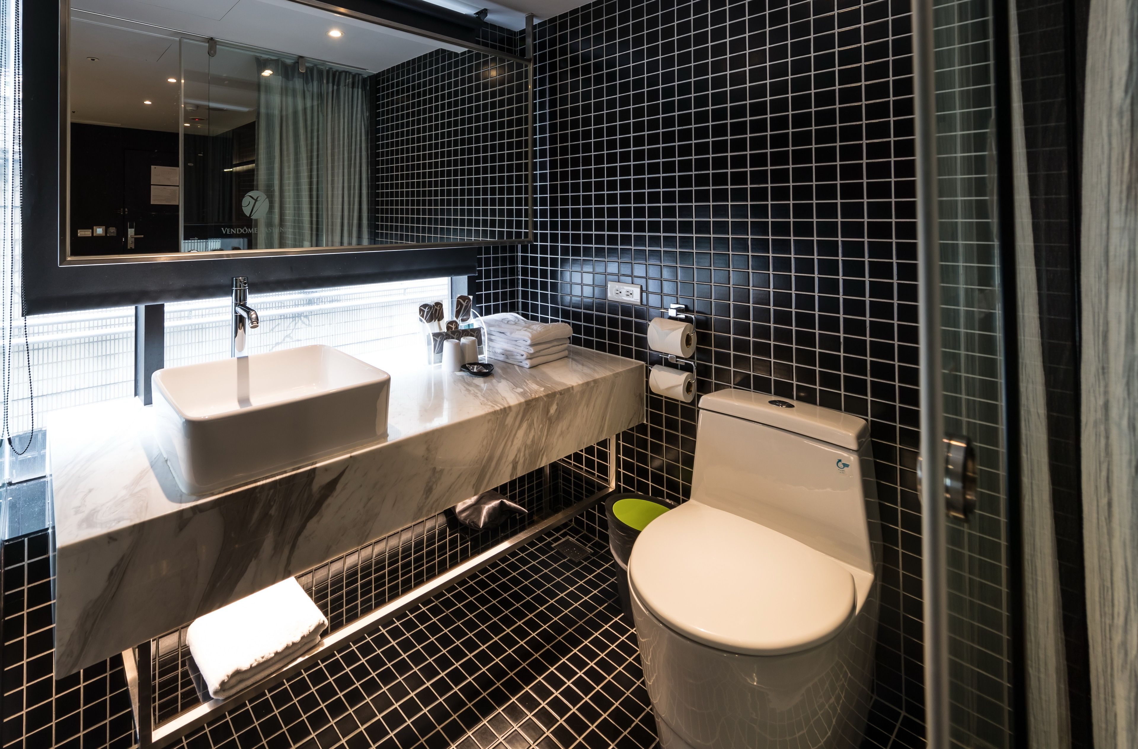A modern bathroom with a dual sink vanity, a toilet, and a large mirror.