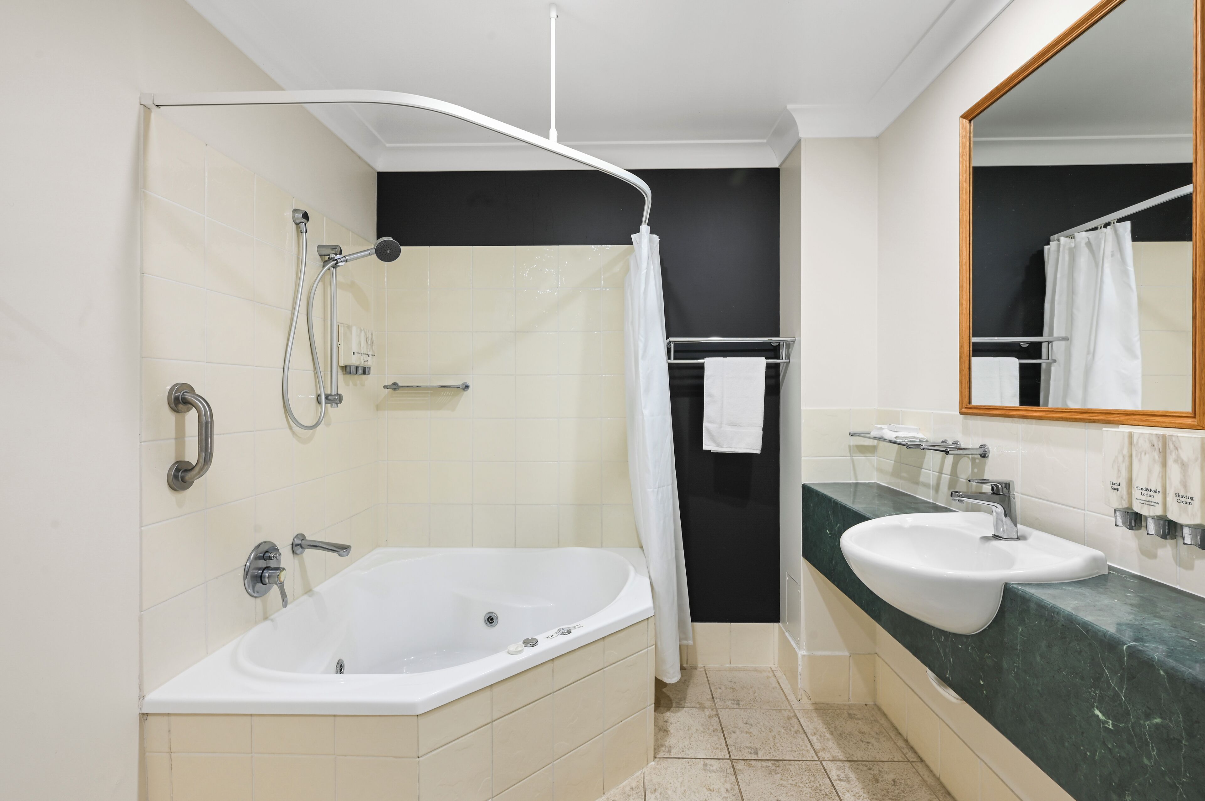 Un bagno moderno con una vasca, una doccia, un lavabo e uno specchio.