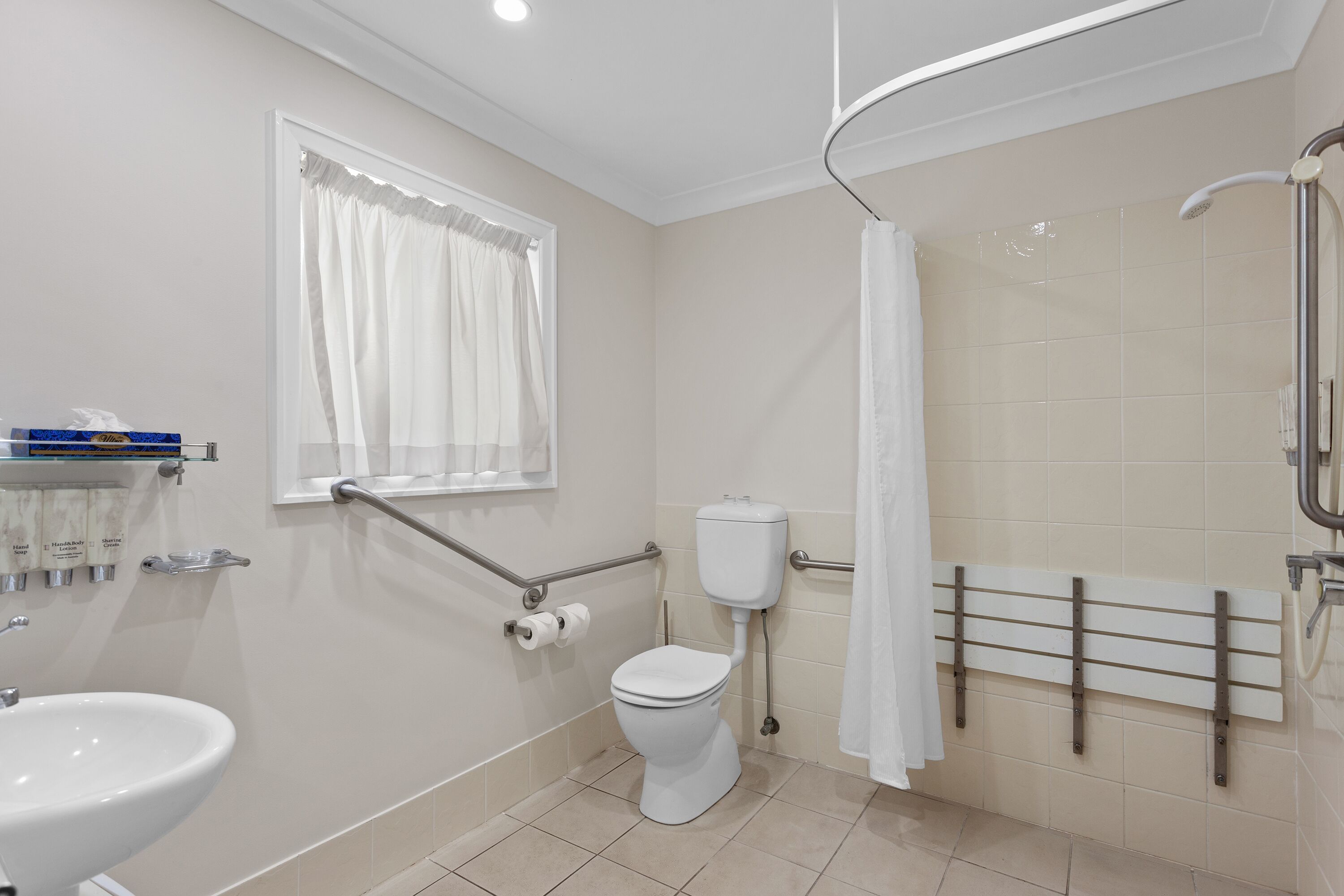 A bathroom with a toilet, sink, and shower.