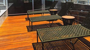 A rooftop terrace with outdoor seating and a view of the cityscape.