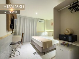 A standard accessible hotel room with a bed, a desk, a chair, a microwave, and a telephone.
