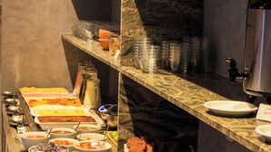 A buffet with various food items and utensils.