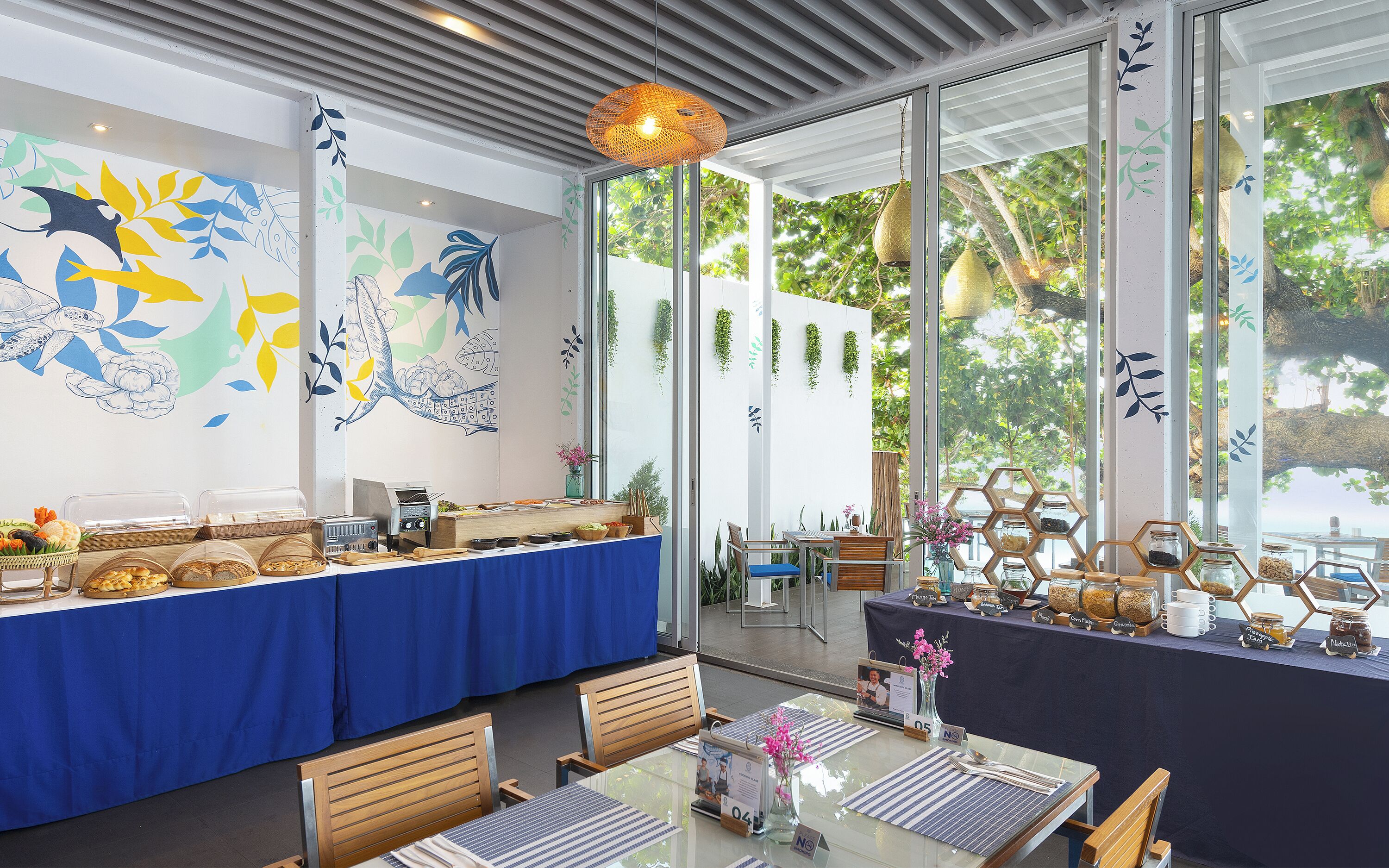 Ein Restaurant mit Buffet, Holzbänken und einem großen Fenster mit Blick auf Bäume.
