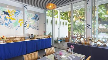 Ein Restaurant mit Buffet, Holzbänken und einem großen Fenster mit Blick auf Bäume.