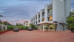 A hotel with a covered entrance, multiple floors, and a parking area. - Hotel Aristro (Mawal)