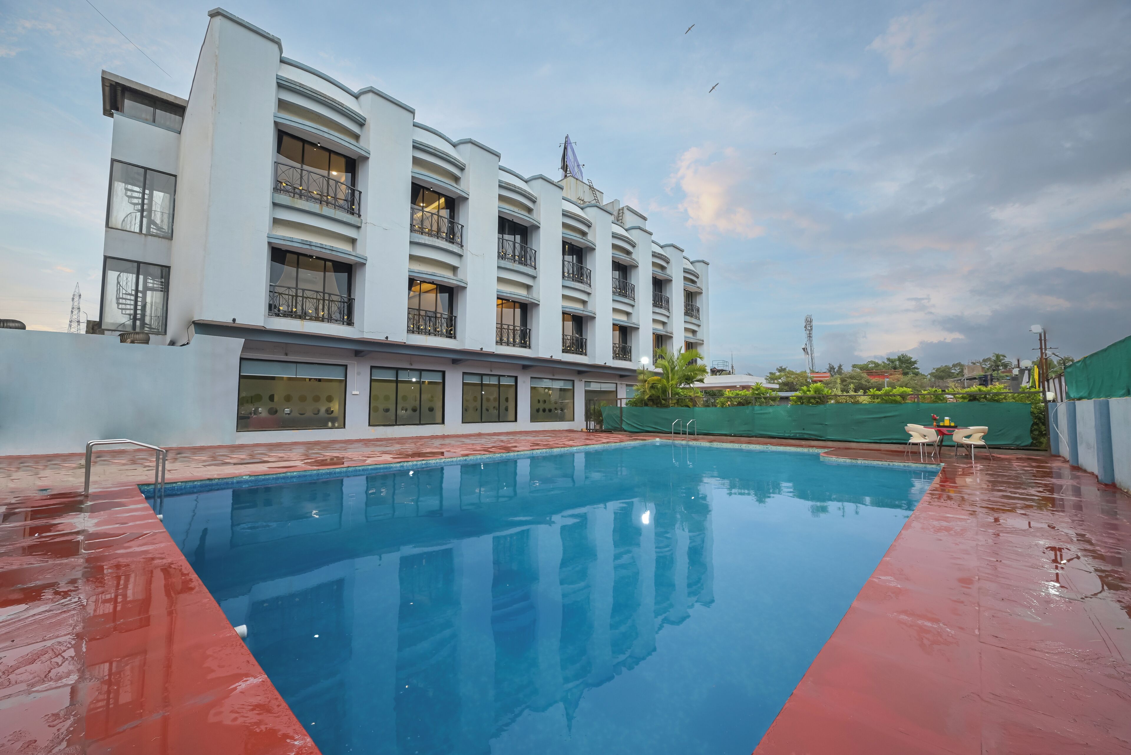 Un hotel moderno con piscina, balcones y vistas del entorno.