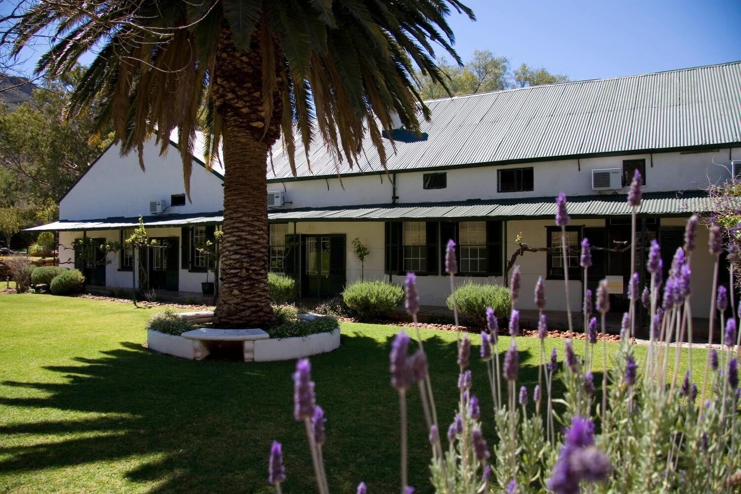 A two-story building with a white exterior and a corrugated metal roof.