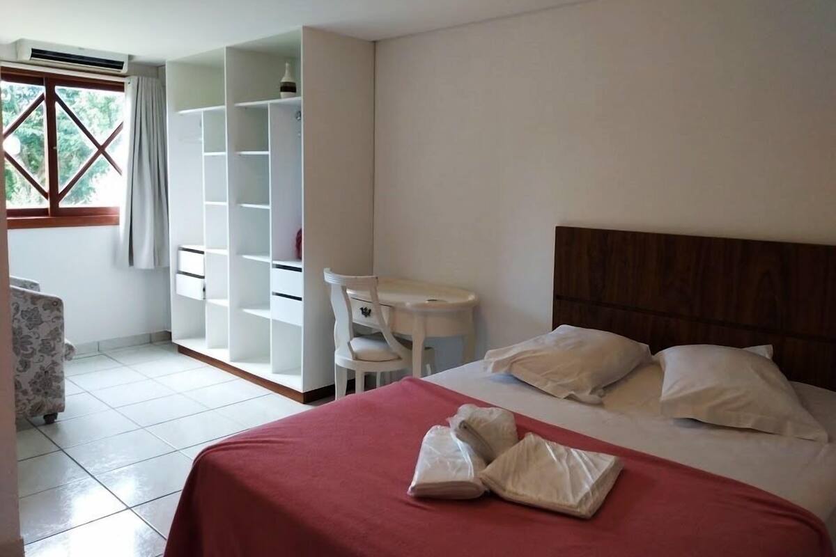 Ein Hotelzimmer mit Bett, Schreibtisch und Kleiderschrank.