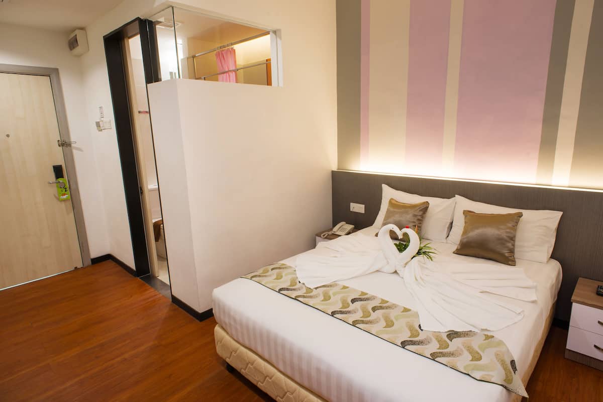 Una habitación de hotel con cama, mesita de noche y armario.