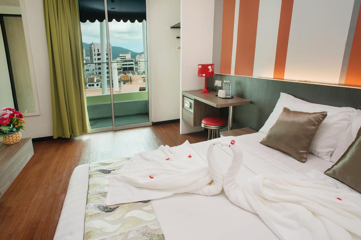 Una habitación de hotel con cama, escritorio, silla y vistas a la ciudad.