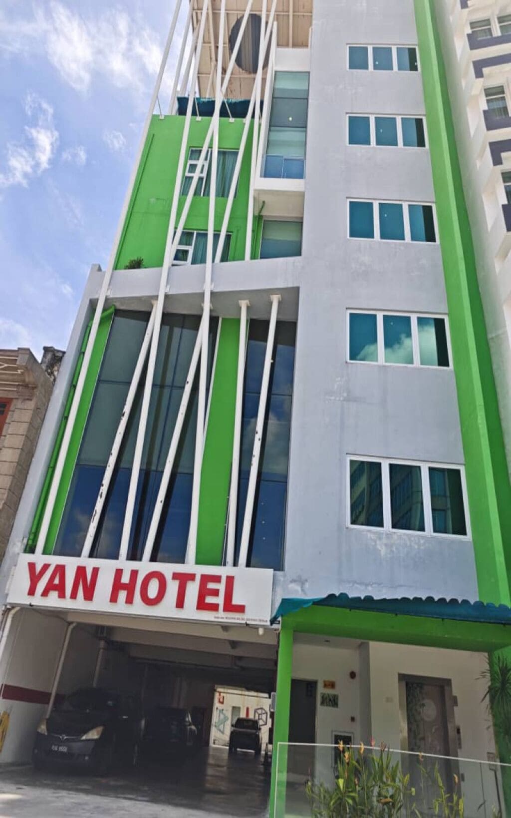 A hotel with a modern design, featuring a prominent 'YAN HOTEL' sign at the entrance.
