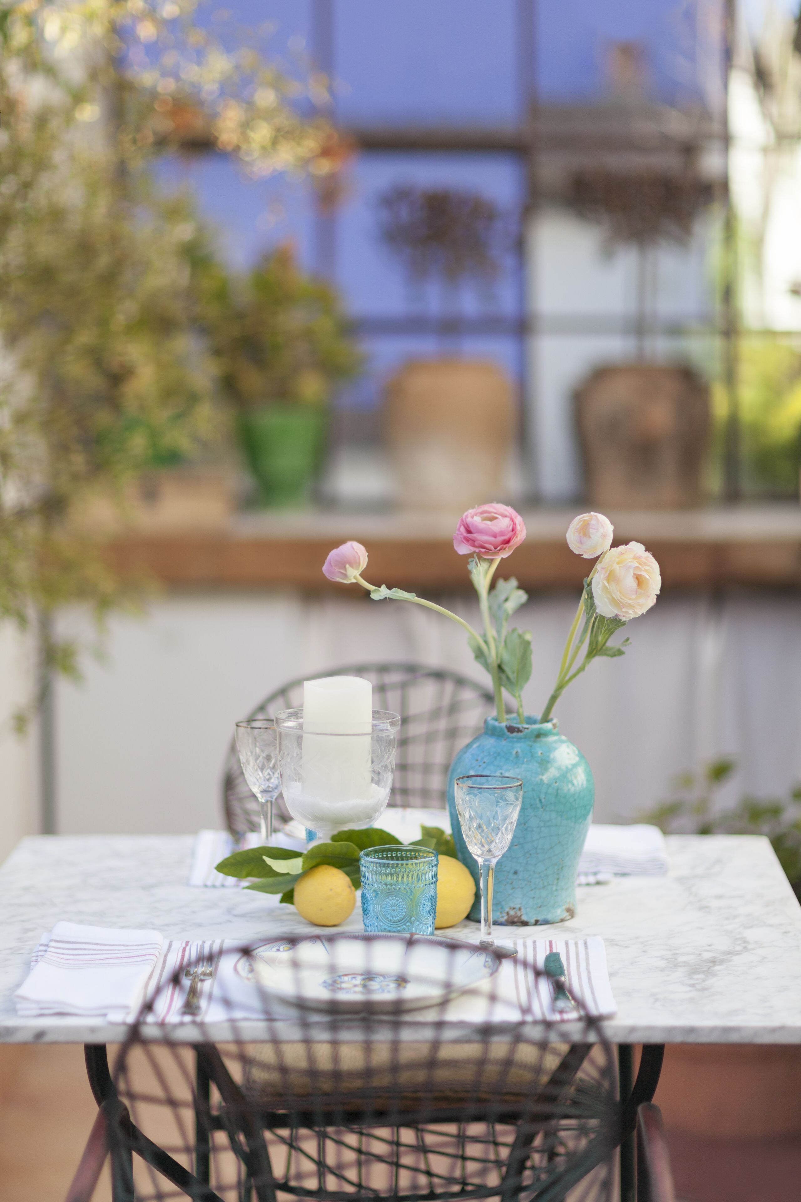A table with a vase of flowers, a candle, and a glass of water.