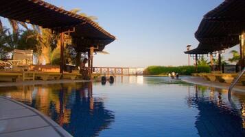 Alberca al aire libre, sombrillas en la alberca y camastros