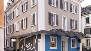 Un edificio de varios pisos con una tienda en la planta baja.