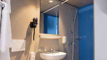 A modern bathroom with a toilet, sink, and shower.