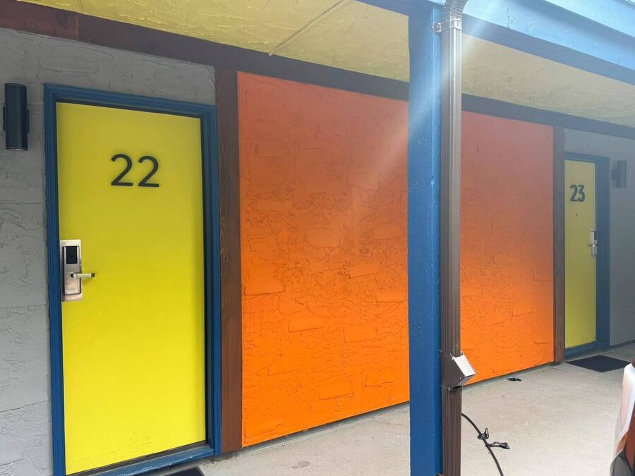 A row of hotel rooms with doors numbered 22 and 23.
