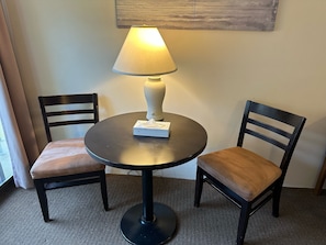 A small round table with a lamp, two chairs, and a tissue box on it. - Wessex Inn By The Sea (Cowichan Bay)