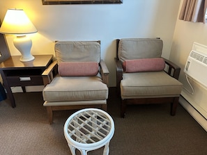 Two armchairs with cushions, a small round table, a lamp, and a radiator. - Wessex Inn By The Sea (Cowichan Bay)