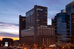 Un hôtel à plusieurs étages, reconnaissable à son grand panneau « Hyatt Place », entouré d’autres immeubles.