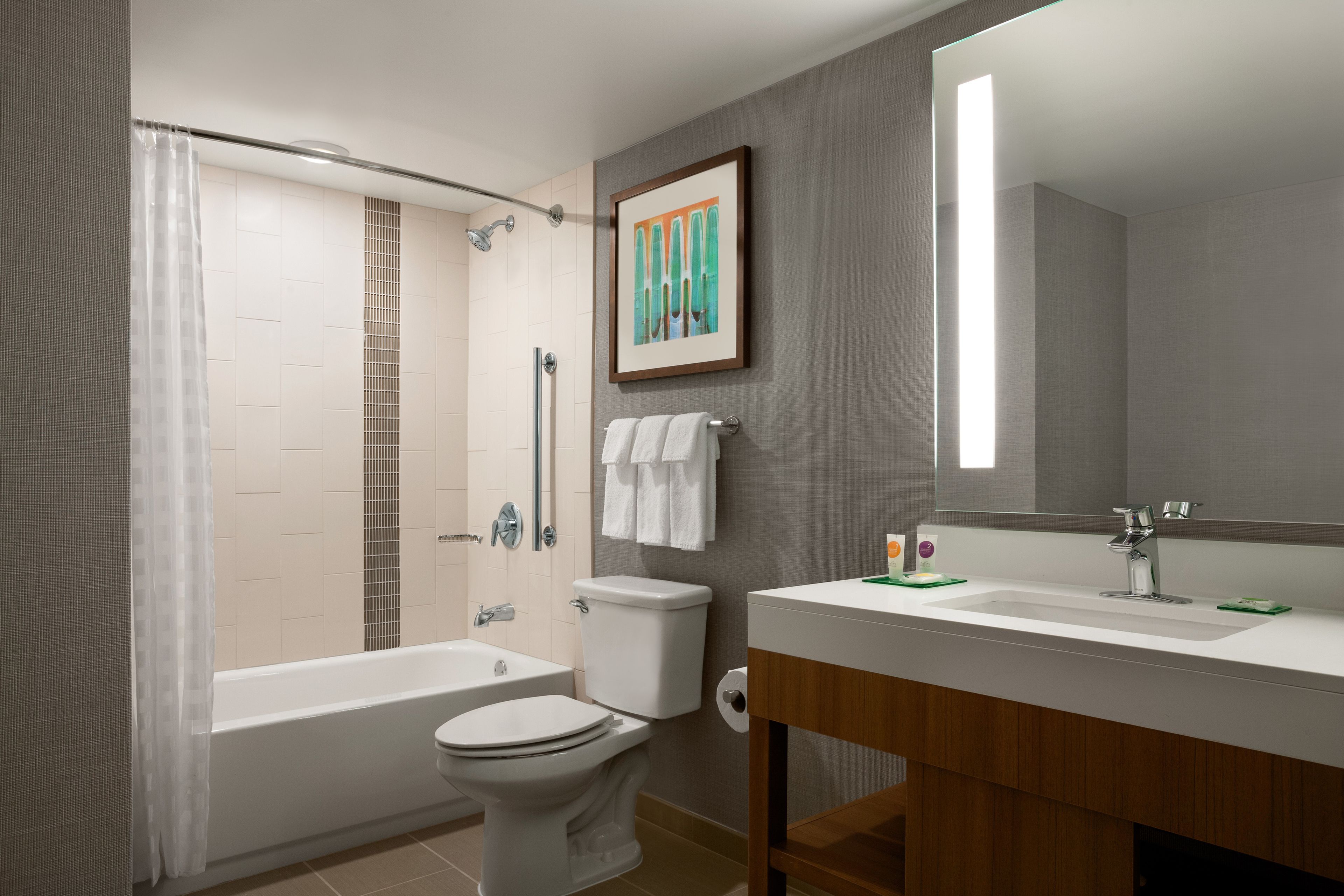 Een moderne badkamer met een bad, toilet en wastafel.