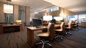 A modern office space with multiple desks, chairs, and computers.