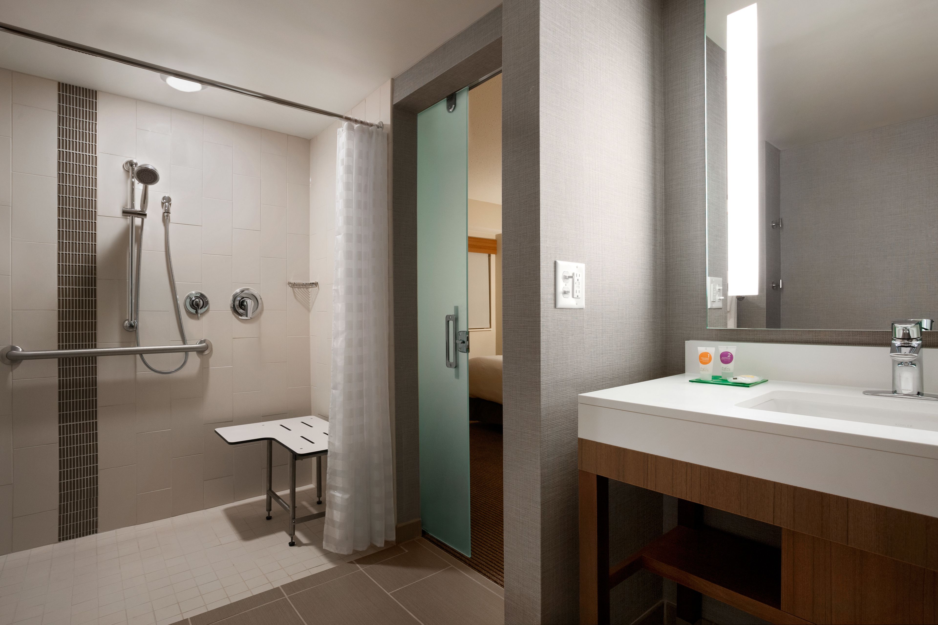 A modern bathroom with a shower, toilet, and sink.