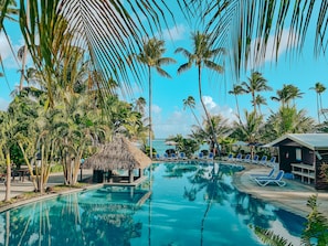 A pool area with lounge chairs and palm trees. - Saletoga Sands Resorts (Matatufu)