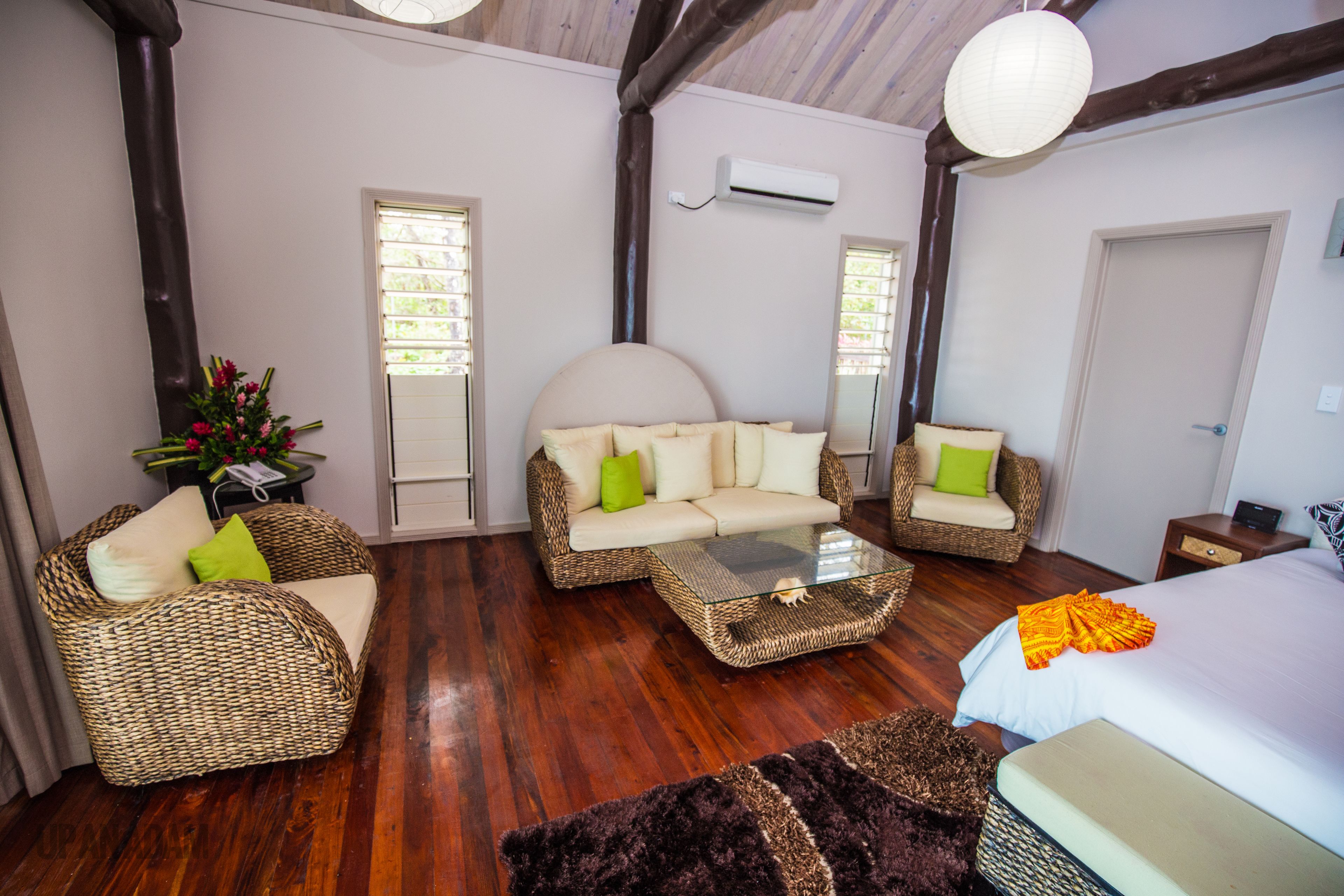 A room with a sofa, a chair, a bed, and a coffee table.