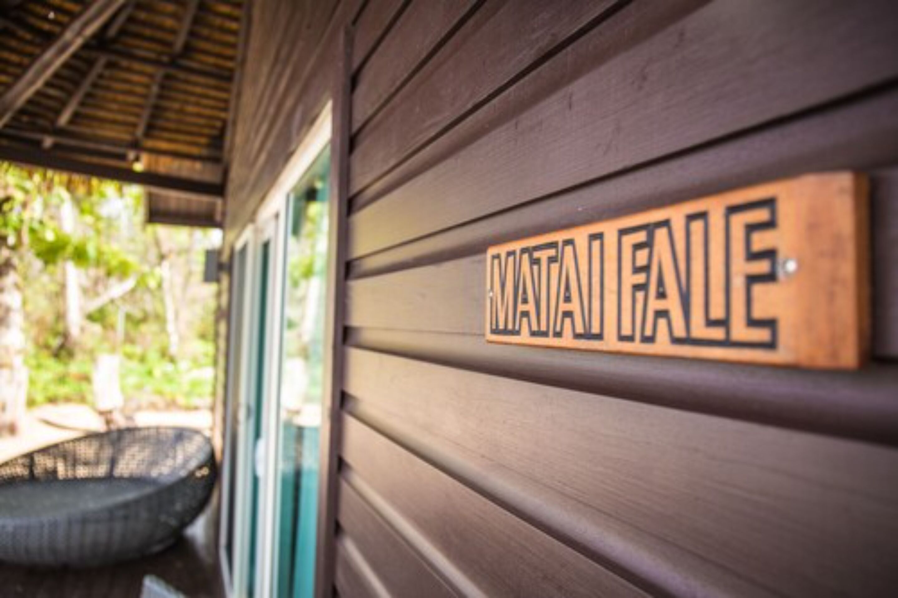 A wooden sign with the name "MATA FALLE" on a building's exterior wall.