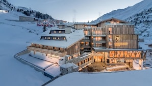 A multi-story hotel with a wooden facade, named 'GURGLHOF', set in a snowy mountainous area. - Hotel Gurglhof (Soelden)