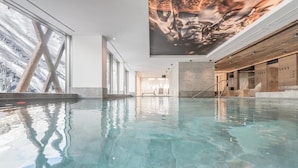 A spacious indoor swimming pool with clear water, large windows, and a modern interior design. - Hotel Gurglhof (Soelden)