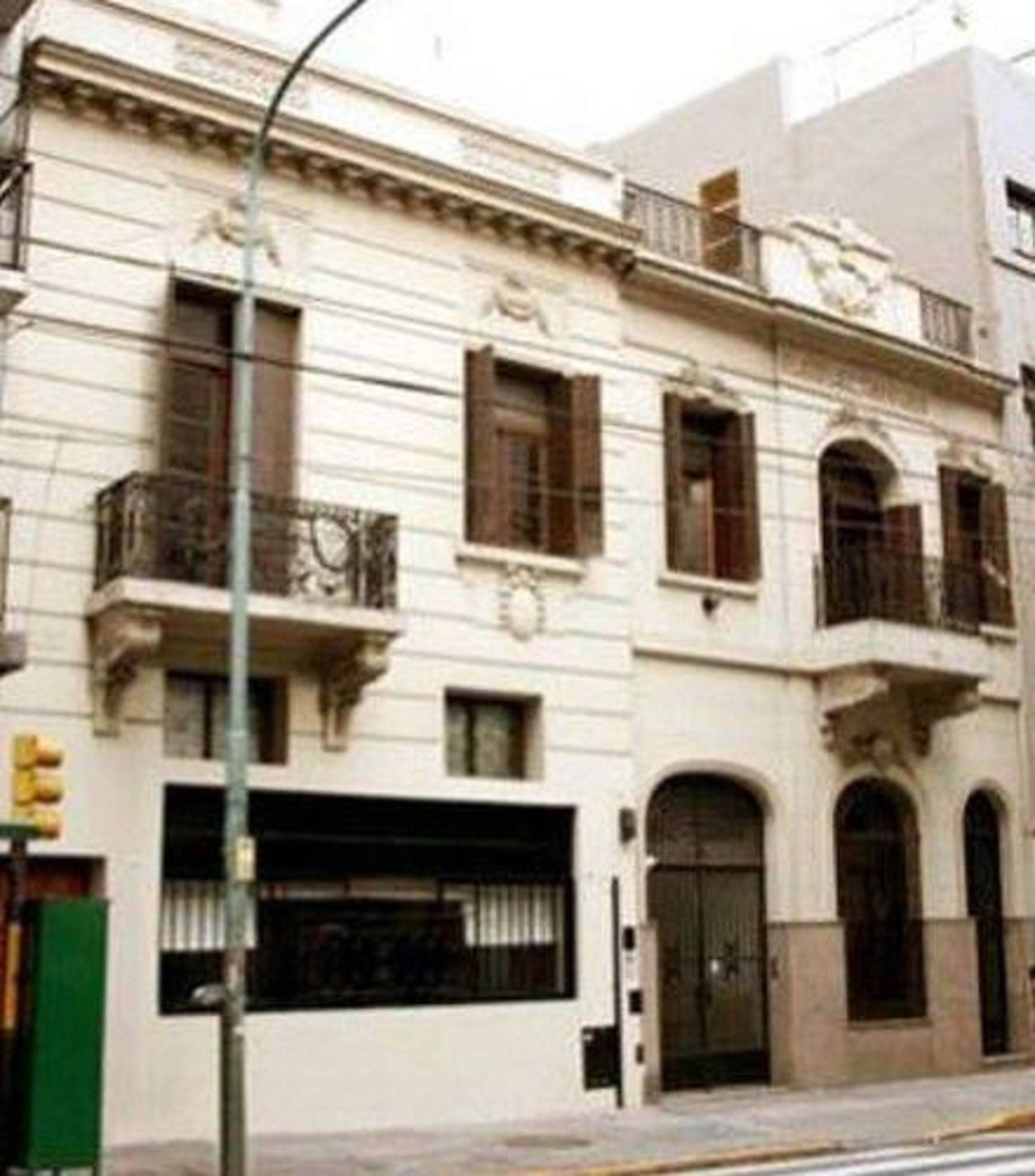Um edifício de vários andares com arquitetura clássica, com varandas e janelas em arco.