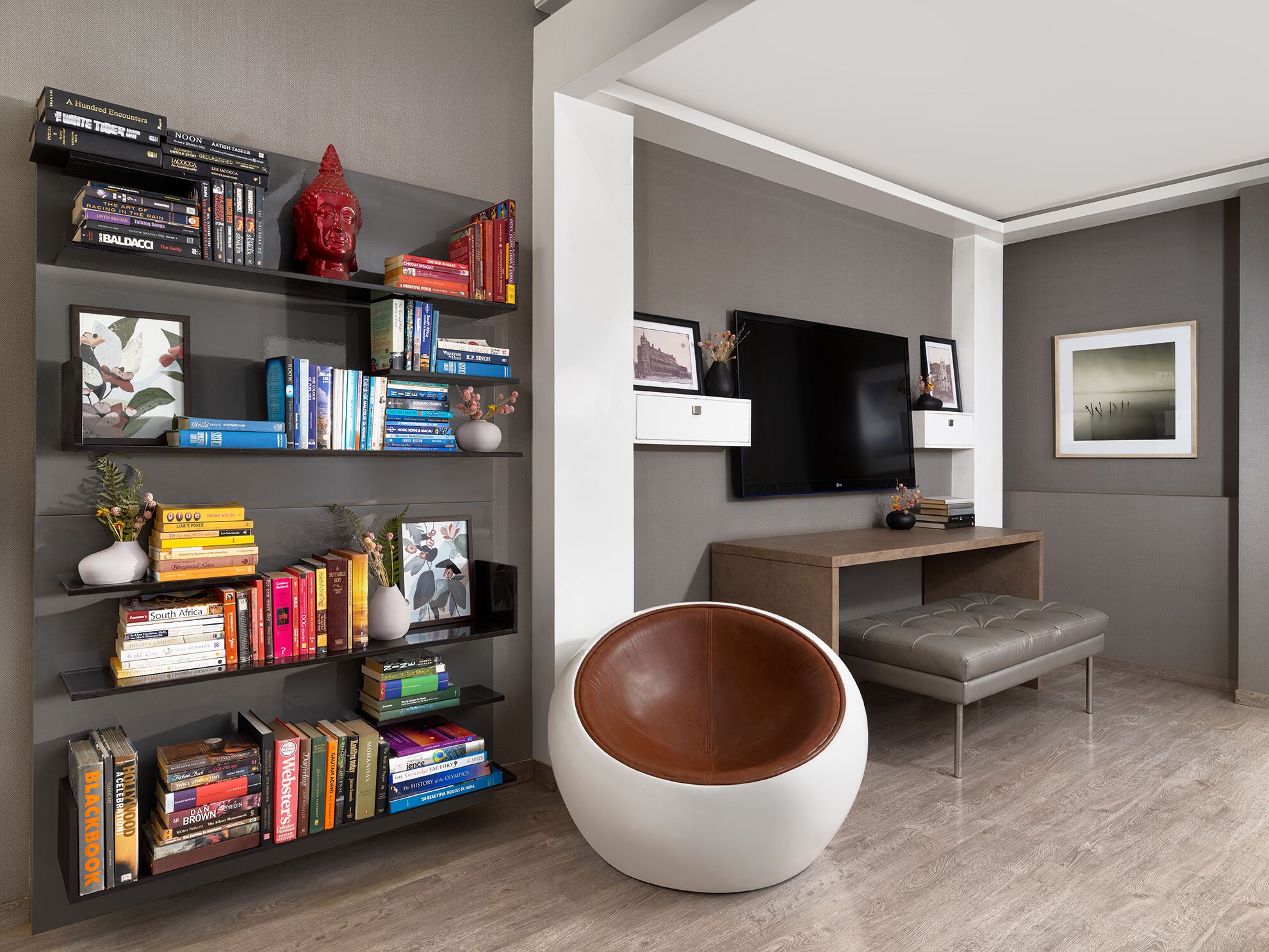 Un soggiorno moderno con una grande libreria, una TV a schermo piatto, un'area salotto confortevole e un design minimalista.